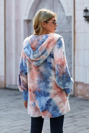 a woman wearing a tie dye coat
