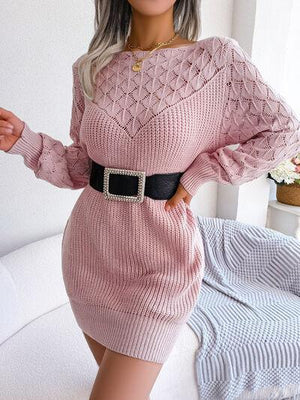 a woman posing in a pink sweater dress