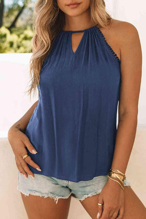 a woman wearing a blue top and denim shorts