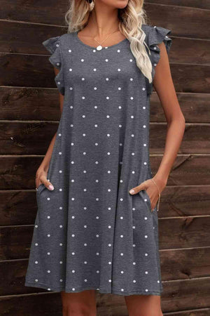 a woman wearing a gray polka dot dress