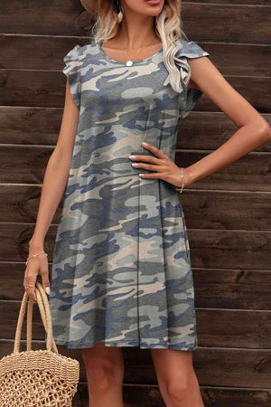 a woman wearing a dress and hat standing in front of a wooden wall