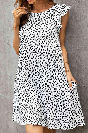 a woman wearing a white and black polka dot dress