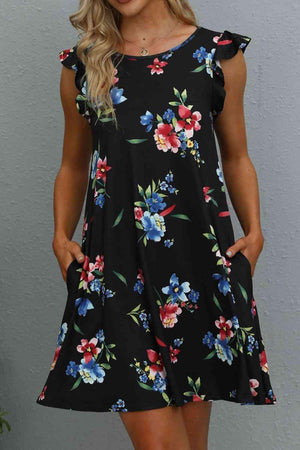 a woman wearing a black floral print dress