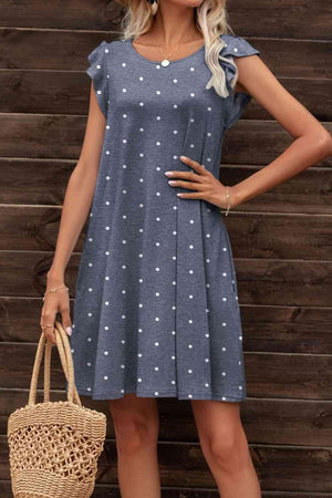 a woman wearing a blue dress with white polka dots