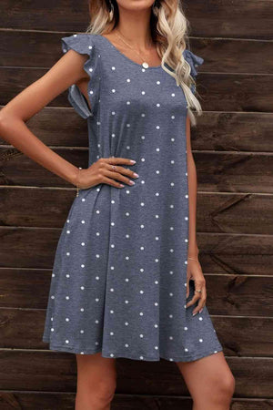 a woman wearing a blue dress with white polka dots