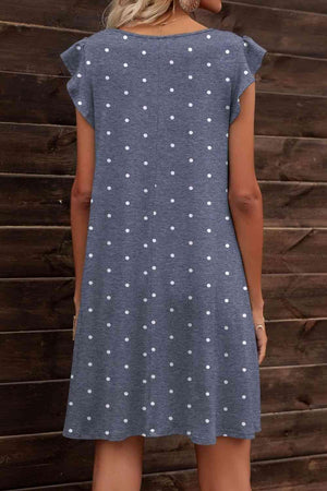 a woman wearing a blue dress with white polka dots