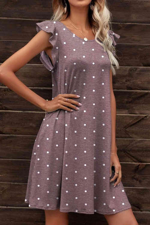 a woman wearing a dress with white polka dots