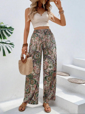 a woman in a white crop top and paisley print pants
