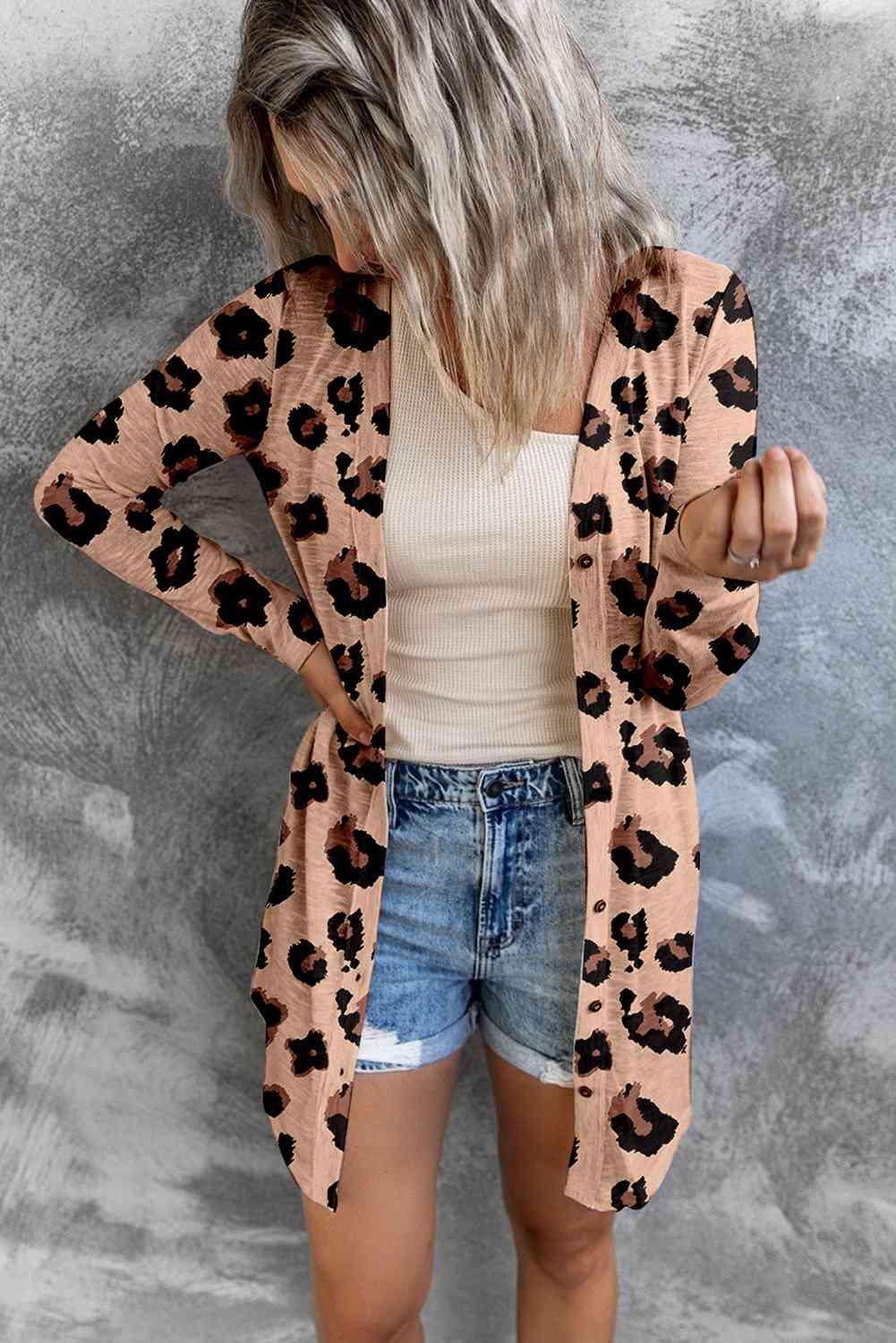 a woman wearing a leopard print cardigan sweater and denim shorts