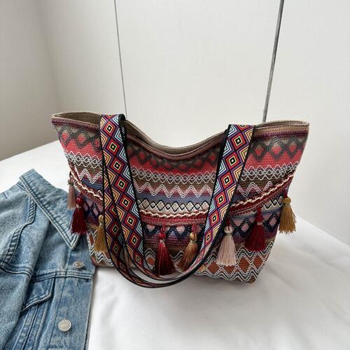 a handbag and a pair of jeans on a bed