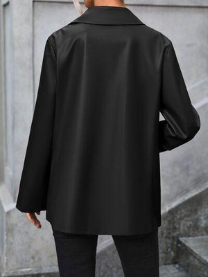 a man in a black jacket is walking down the street