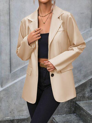 a woman wearing a tan jacket and black pants