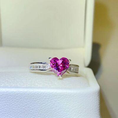 a pink heart shaped diamond ring sitting on top of a white box