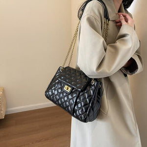 a woman in a white coat holding a black purse
