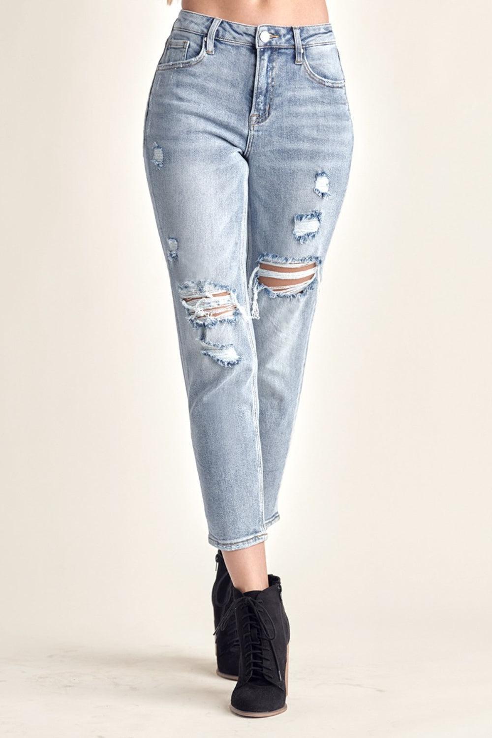 a woman wearing ripped jeans and black boots
