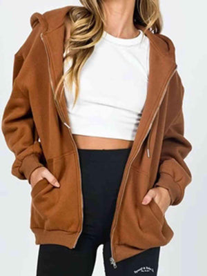 a woman wearing a brown jacket and black pants