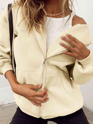 a woman wearing a white jacket and black pants