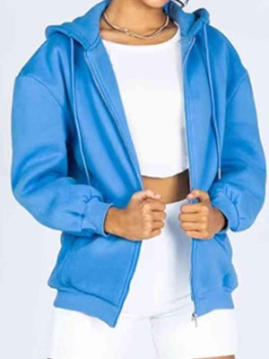 a woman wearing a blue jacket and white shorts