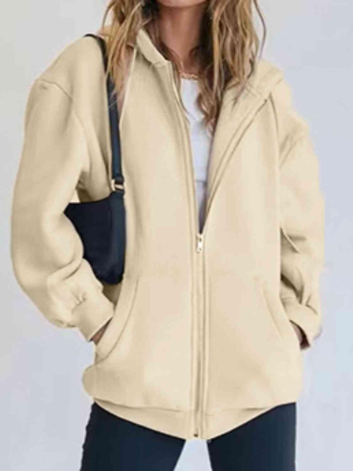 a woman wearing a beige jacket and black pants