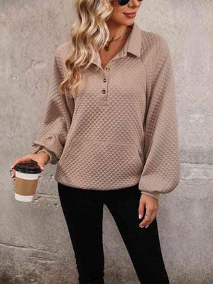 a woman wearing a tan sweater and black pants
