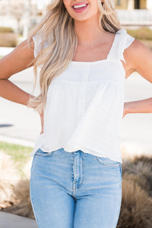 a woman wearing a white top and jeans