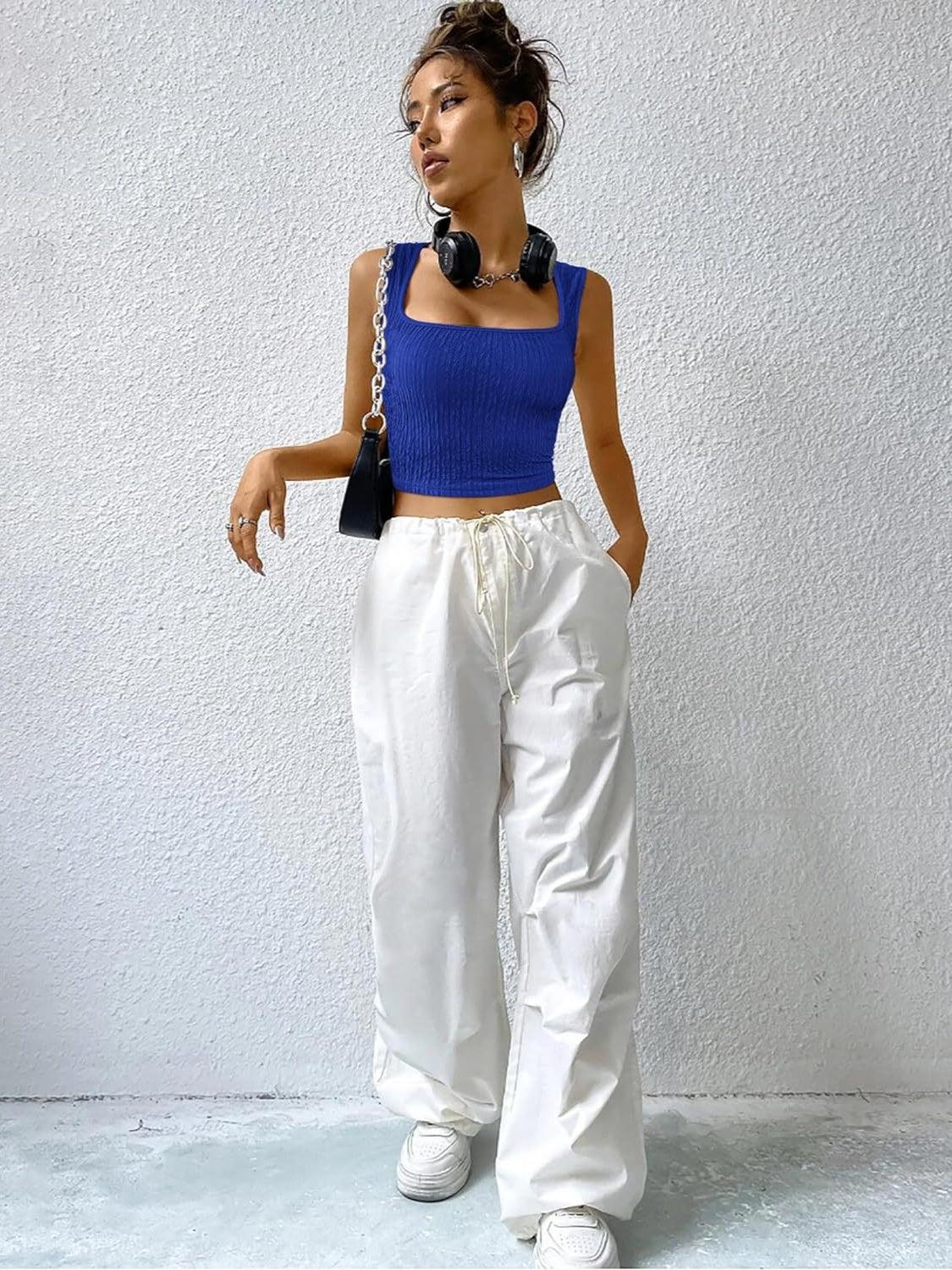 a woman wearing white pants and a blue top