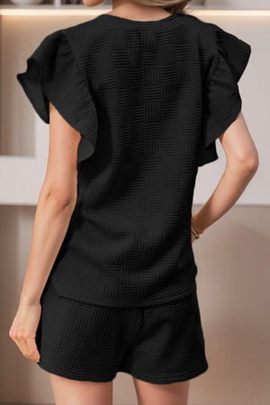 a woman wearing a black top and shorts