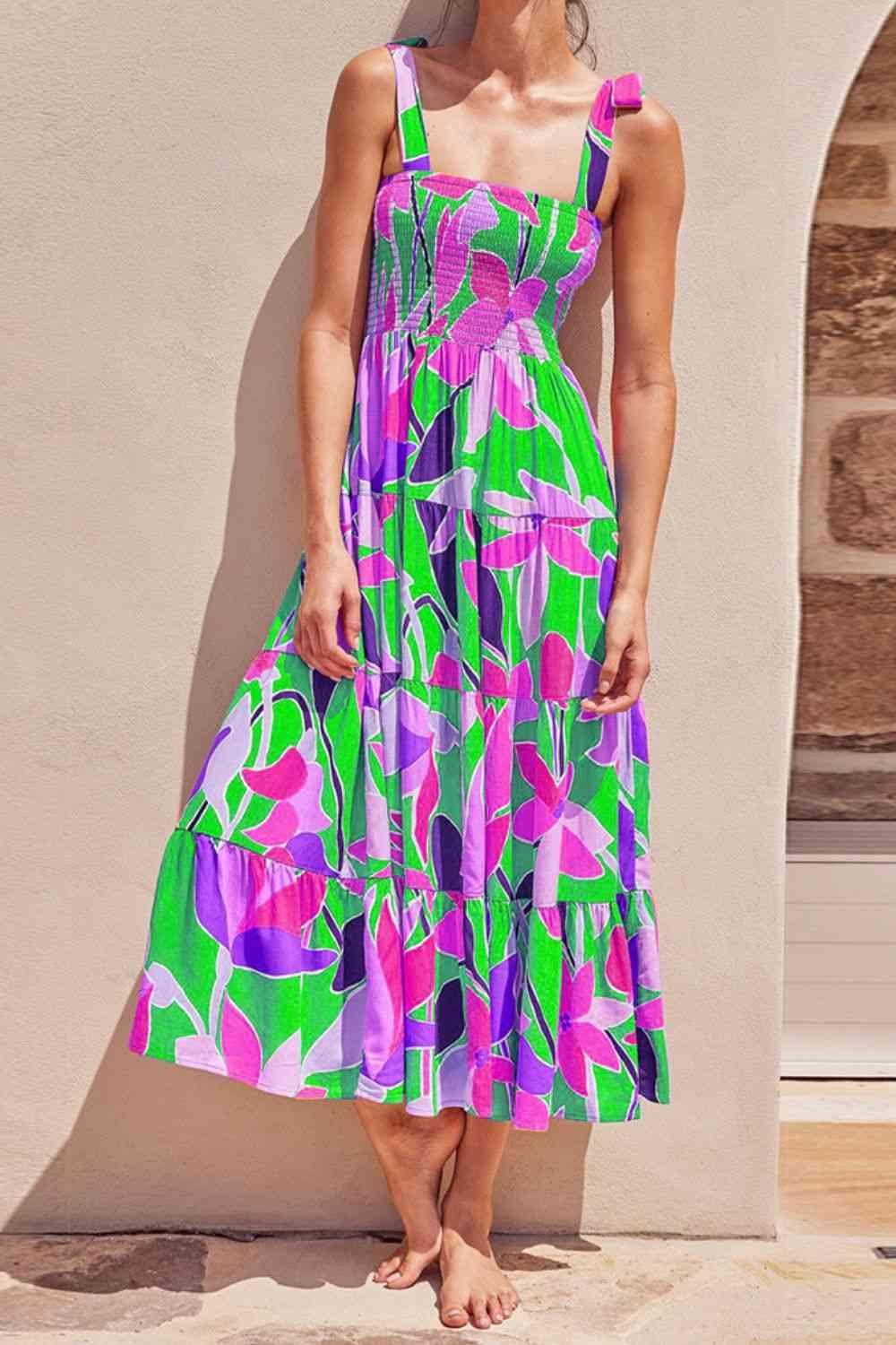 a woman standing against a wall wearing a colorful dress