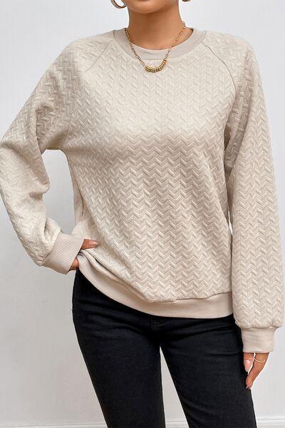 a woman wearing a white sweater and black pants