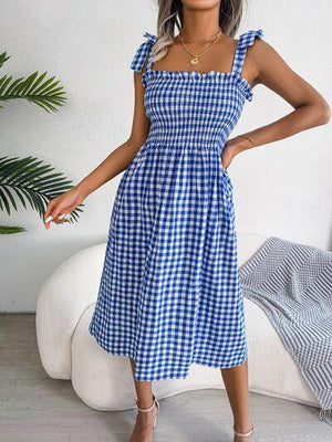 a woman wearing a blue and white checkered dress