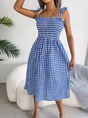 a woman wearing a blue and white checkered dress