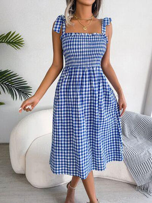 a woman wearing a blue and white checkered dress