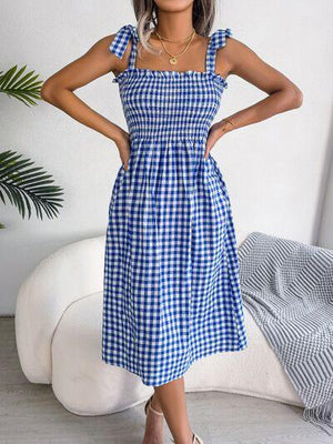 a woman wearing a blue and white checkered dress