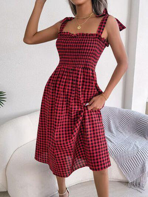 a woman wearing a red and black checkered dress