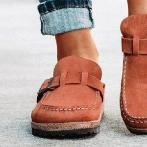 a close up of a person wearing a pair of brown shoes