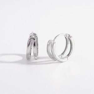 a pair of silver hoop earrings on a white background