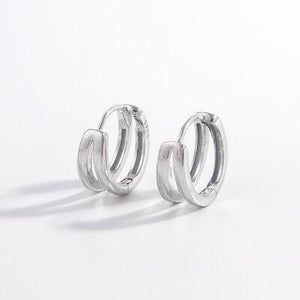a pair of silver hoop earrings on a white background