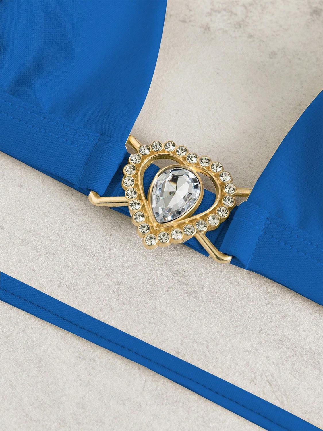 a close up of a brooch with a blue ribbon