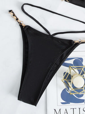 a black bikini top with a gold chain