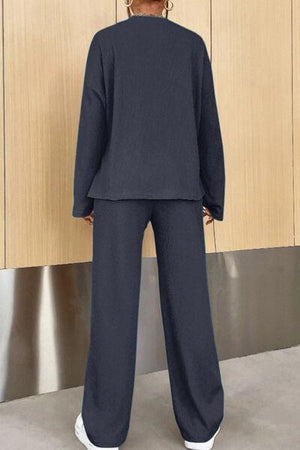 a woman standing in front of a wooden wall