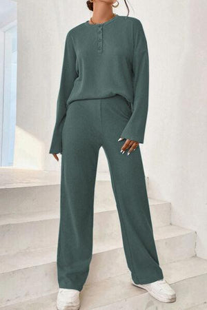 a woman in a green jumpsuit standing on some steps