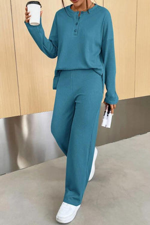 a woman in a teal outfit holding a cup of coffee