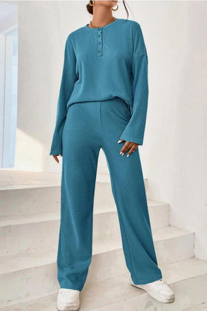 a woman standing on a set of stairs wearing a blue jumpsuit