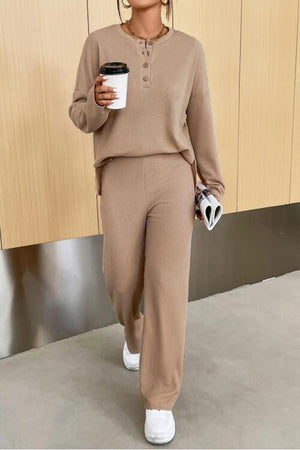 a woman holding a cup of coffee and wearing a pair of sweatpants