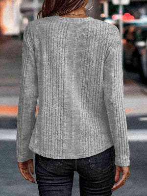 a woman wearing a gray sweater and jeans