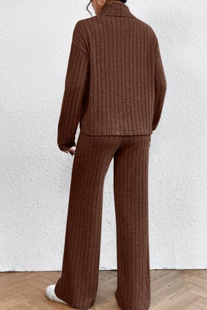a woman wearing a brown sweater and wide legged pants