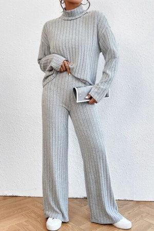 a woman wearing a grey sweater and pants