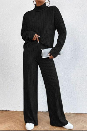 a woman wearing a black sweater and pants