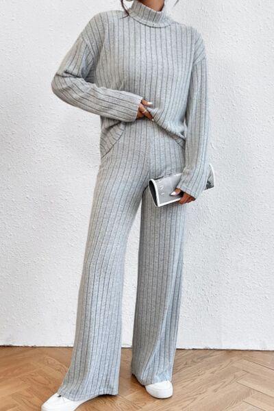 a woman wearing a grey sweater and pants