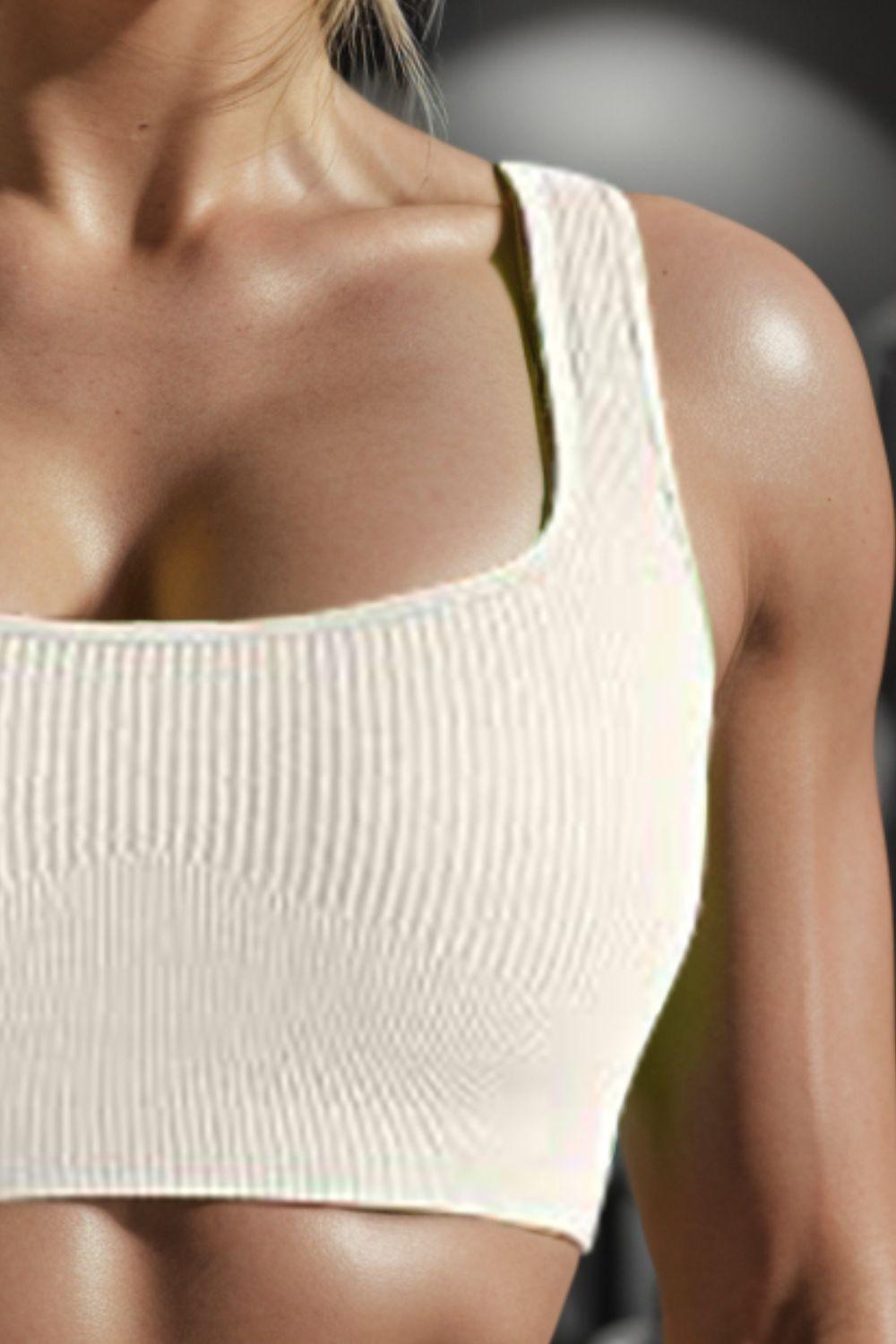 a woman in a sports bra top holding a tennis racquet